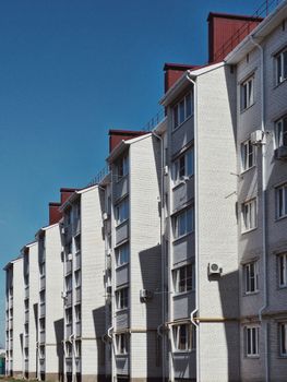 Series of modern apartment buildings with a clear blue sky background, capturing urban architectural design.