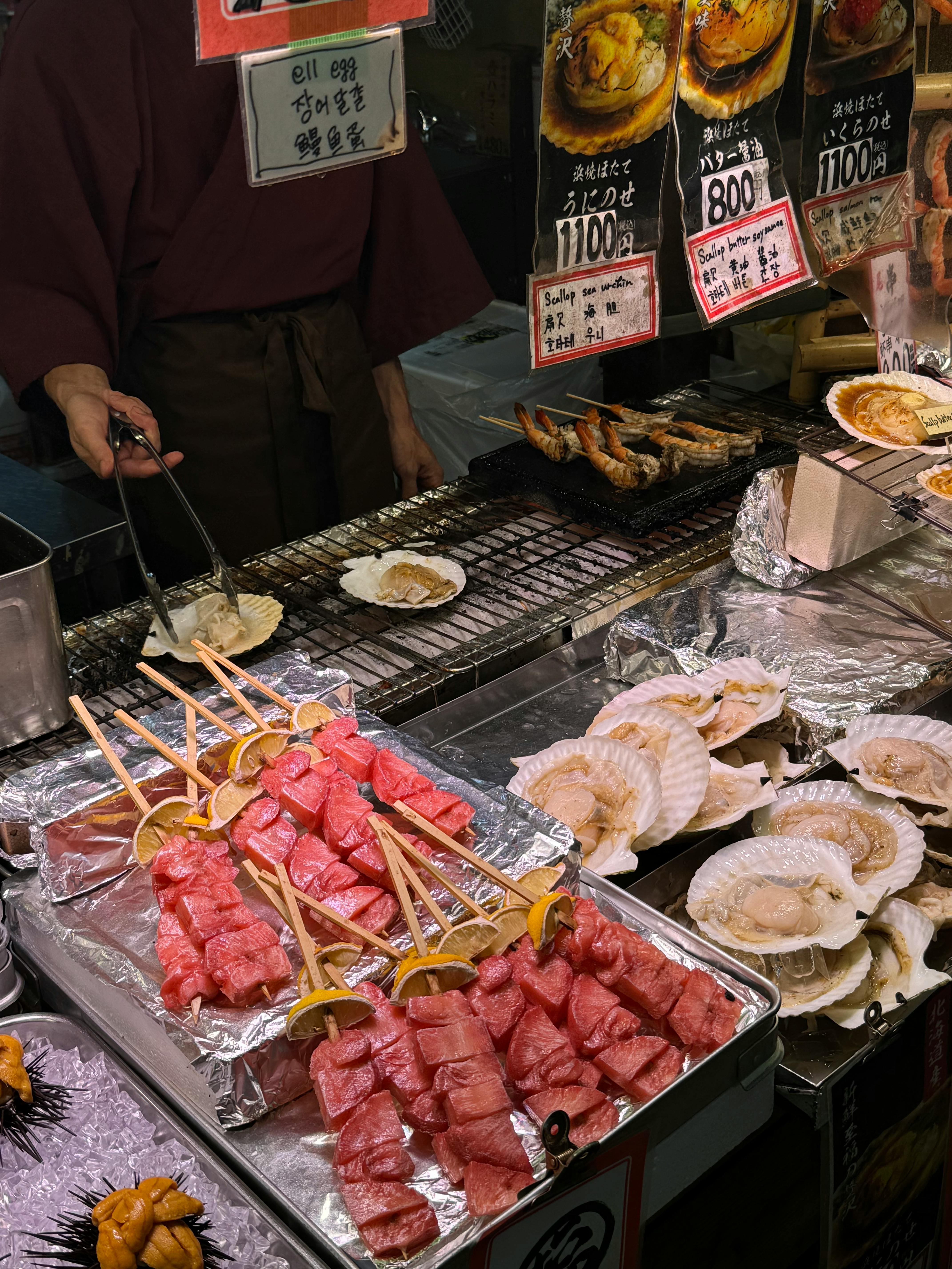 A bustling Japanese street food stall offering fresh seafood in Osaka. Vibrant night scene.