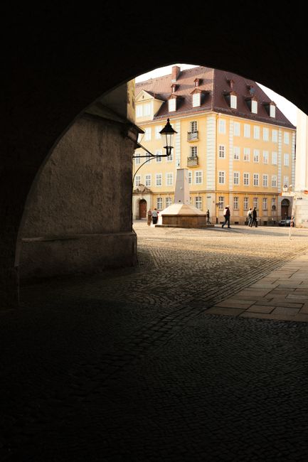 A scenic street view in Görlitz, Saxony, Germany, featuring classic architecture under an archway.