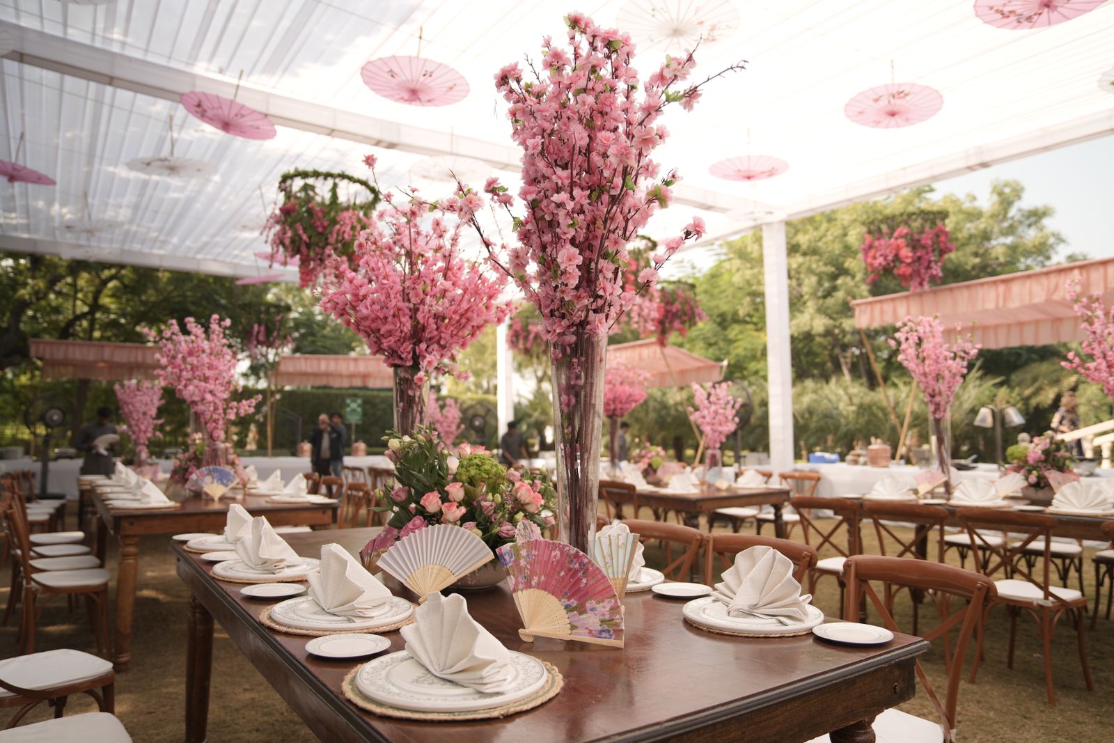 Outdoor wedding reception seating with pink floral decoration
