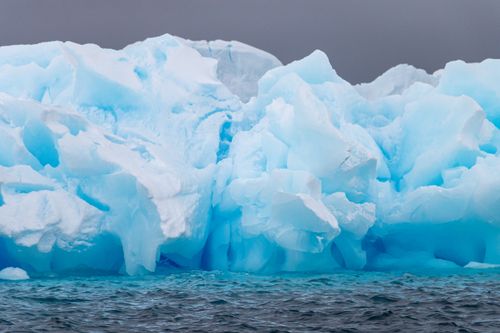 Free A stunning view of a massive blue iceberg floating in the icy waters of Antarctica. Stock Photo