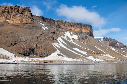 Stunning view of a snow-capped mountain in Antarctica reflecting in calm waters.