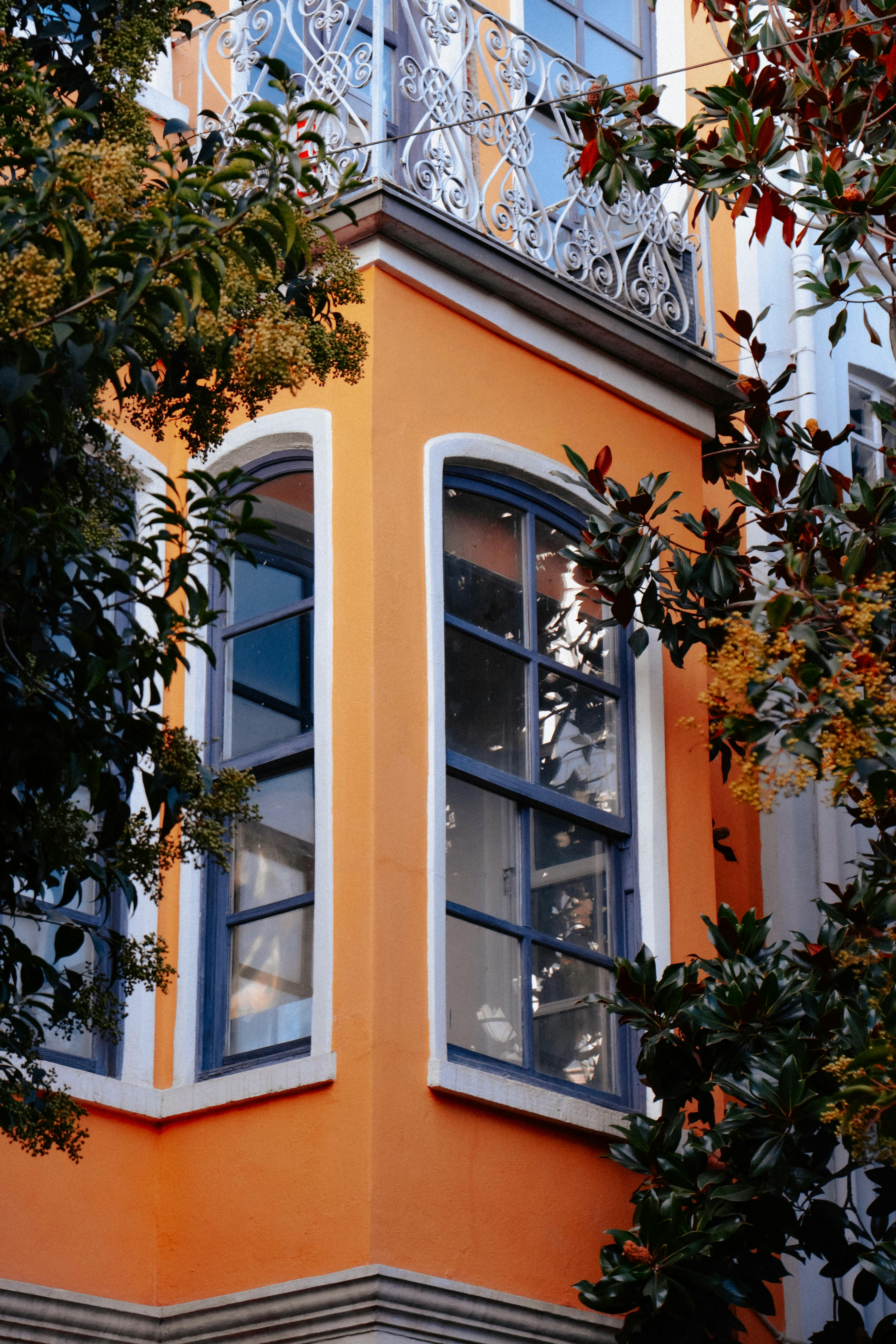 Decorative orange building facade with lush greenery in Istanbul, Türkiye.