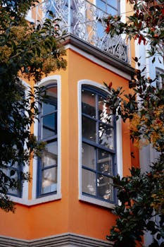 Decorative orange building facade with lush greenery in Istanbul, Türkiye.