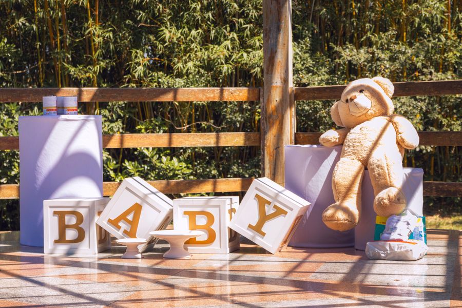 Outdoor baby shower décor with teddy bear and BABY letter boxes