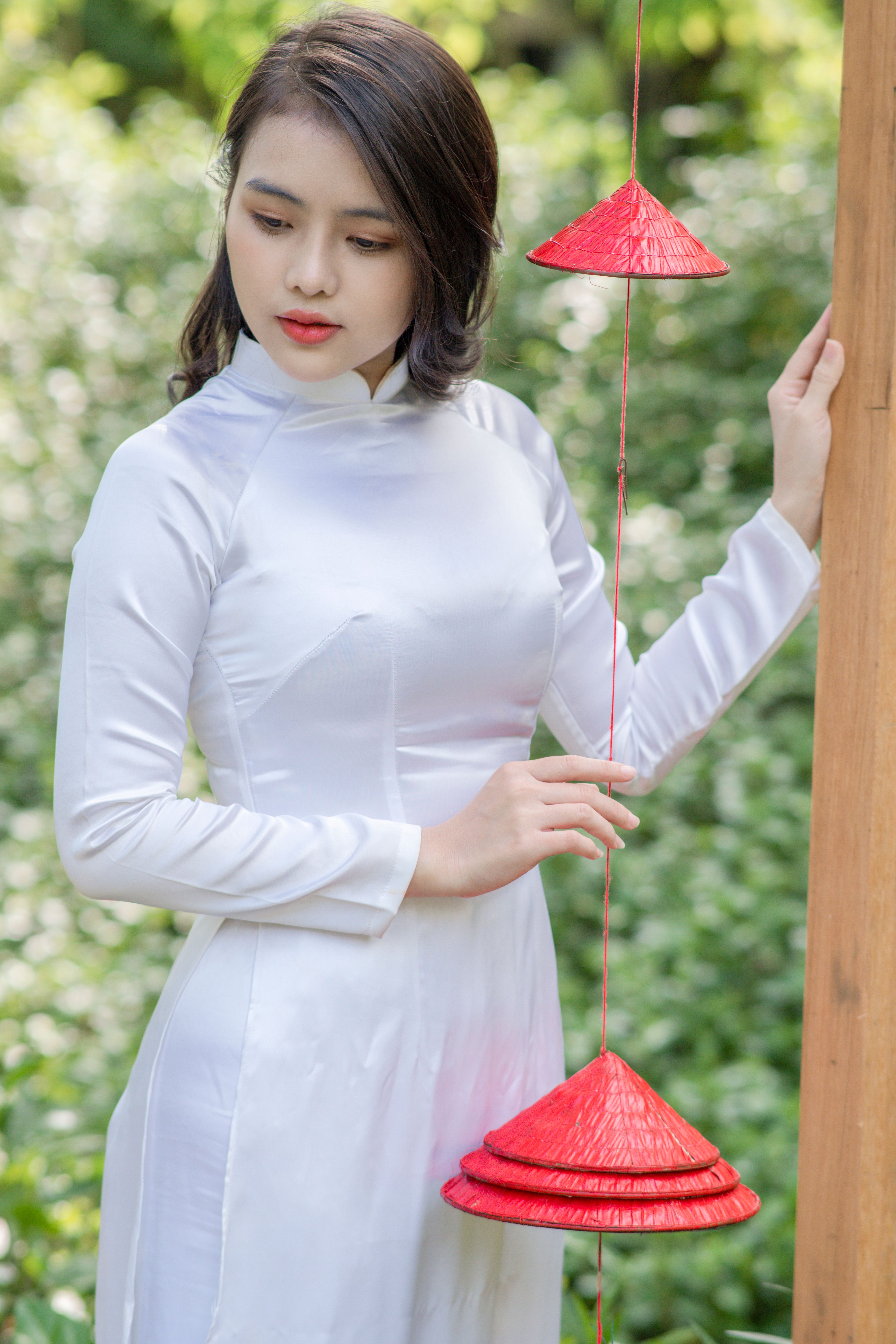 Woman in Traditional Dress Holding Red Straw Hat · Free Stock Photo
