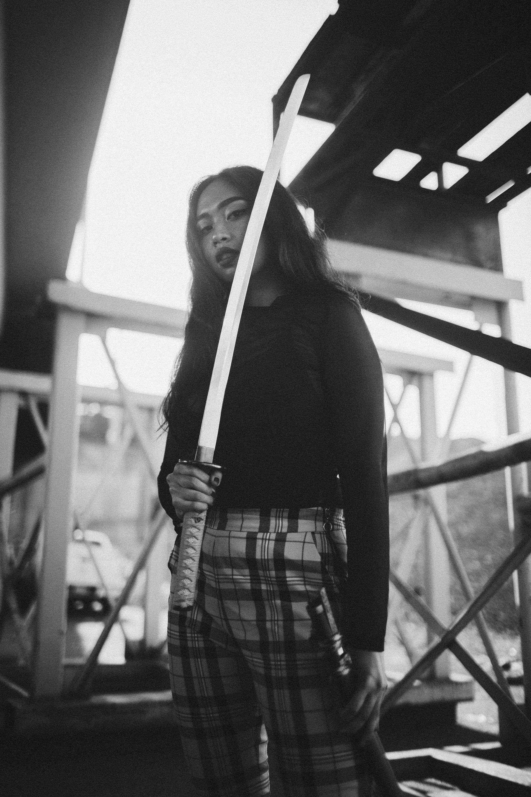 Martial artist holding a traditional sword against a neutral background