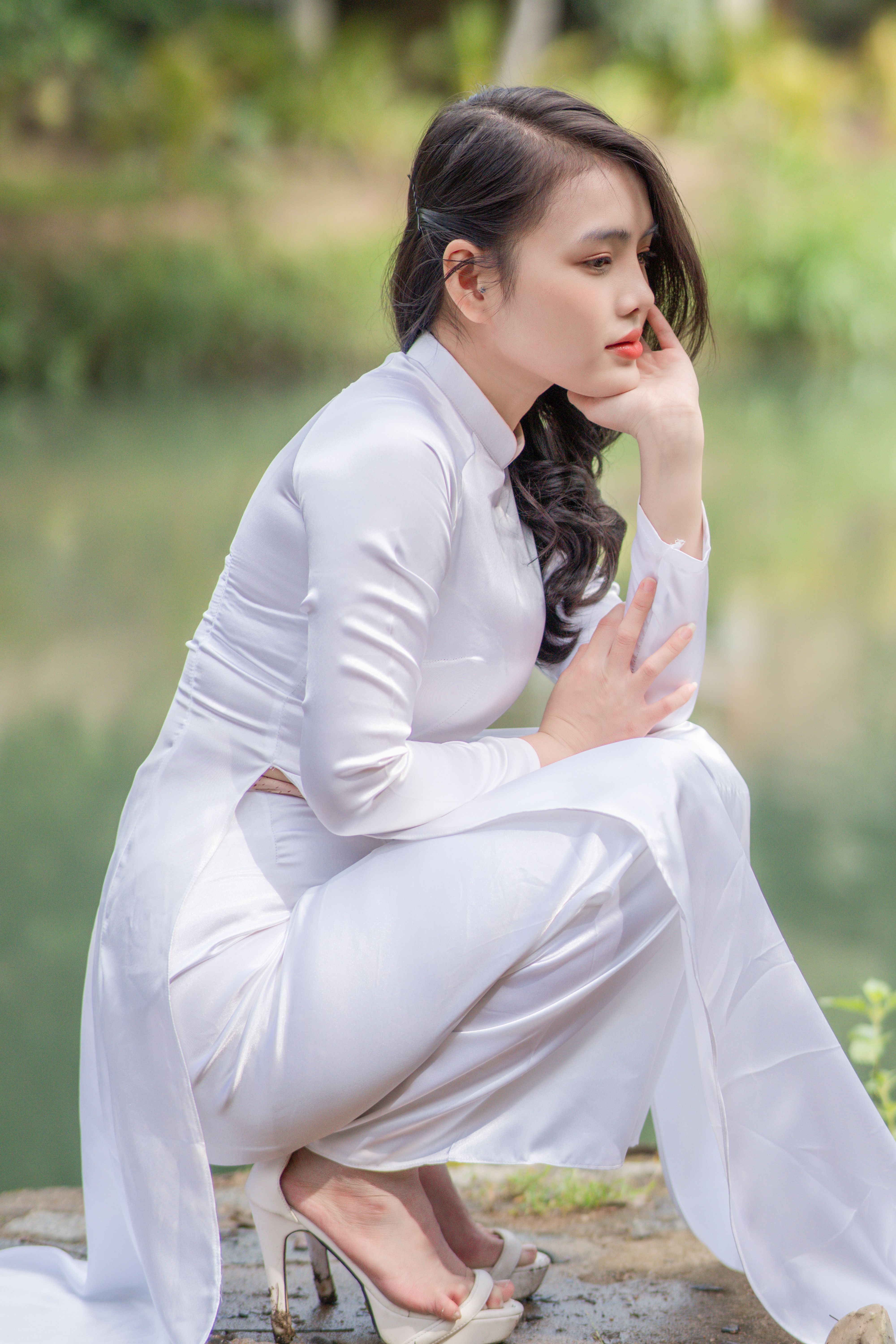 Elegant Woman in Traditional White Attire by a Lake · Free Stock Photo