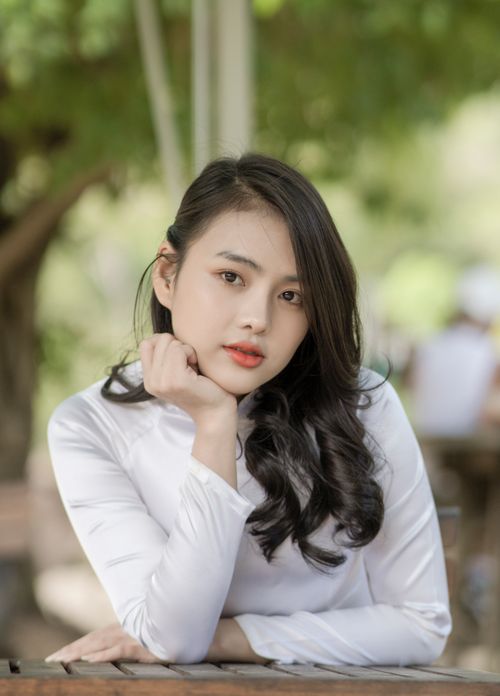 Free Elegant young woman in white blouse posing outdoors, exuding natural beauty. Stock Photo