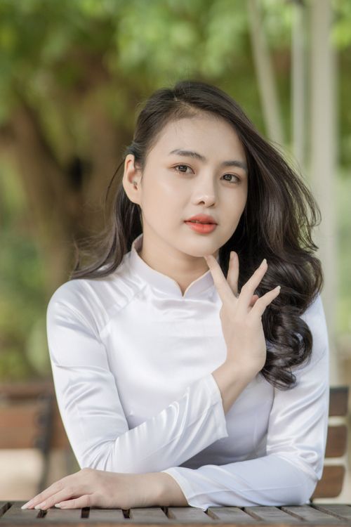Free Portrait of a young woman wearing a traditional white dress indoors with a serene expression. Stock Photo
