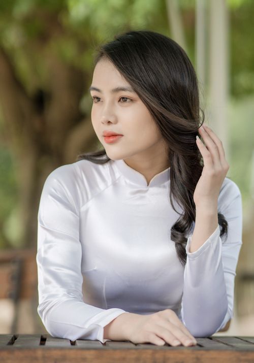 Free Elegant portrait of a woman in white traditional dress looking thoughtfully outdoors. Stock Photo