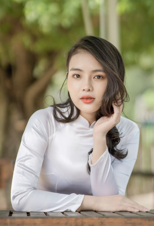 Free Serene portrait of a woman in white attire outdoors, blending elegance and nature. Stock Photo