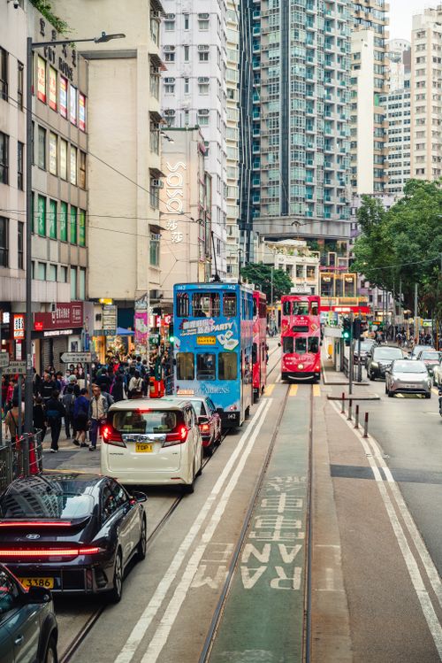 Free Bustling Hong Kong street scene with trams, cars, and skyscrapers showcasing urban life. Stock Photo