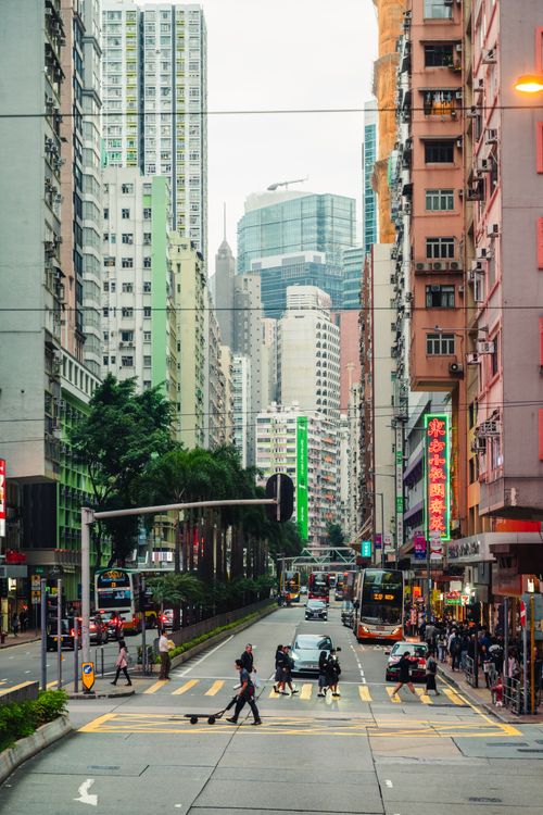 Free Vibrant street scene capturing daily life amidst Hong Kong's towering skyscrapers. Stock Photo