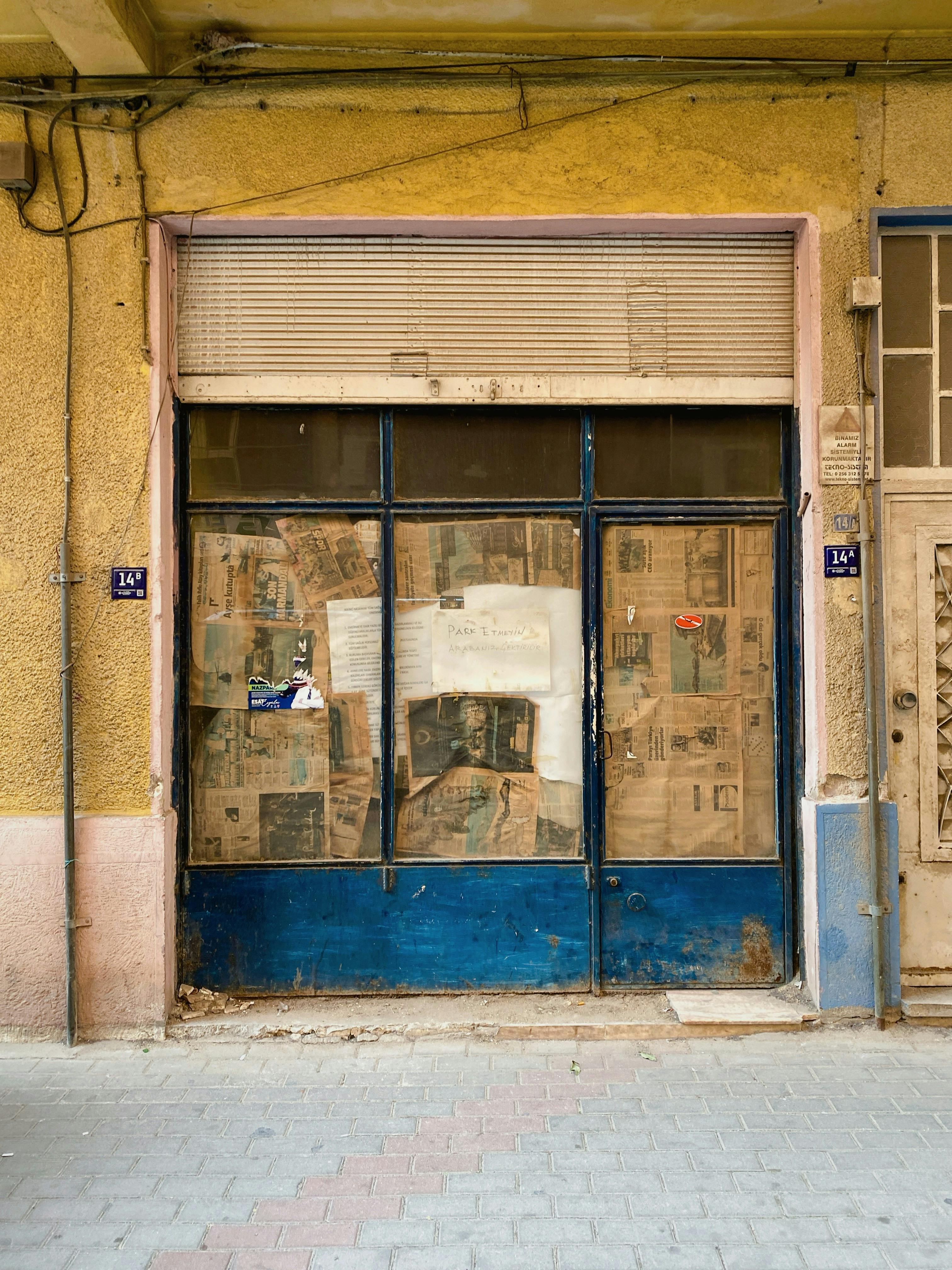 Closed Shopfront with Paper-Covered Windows · Free Stock Photo