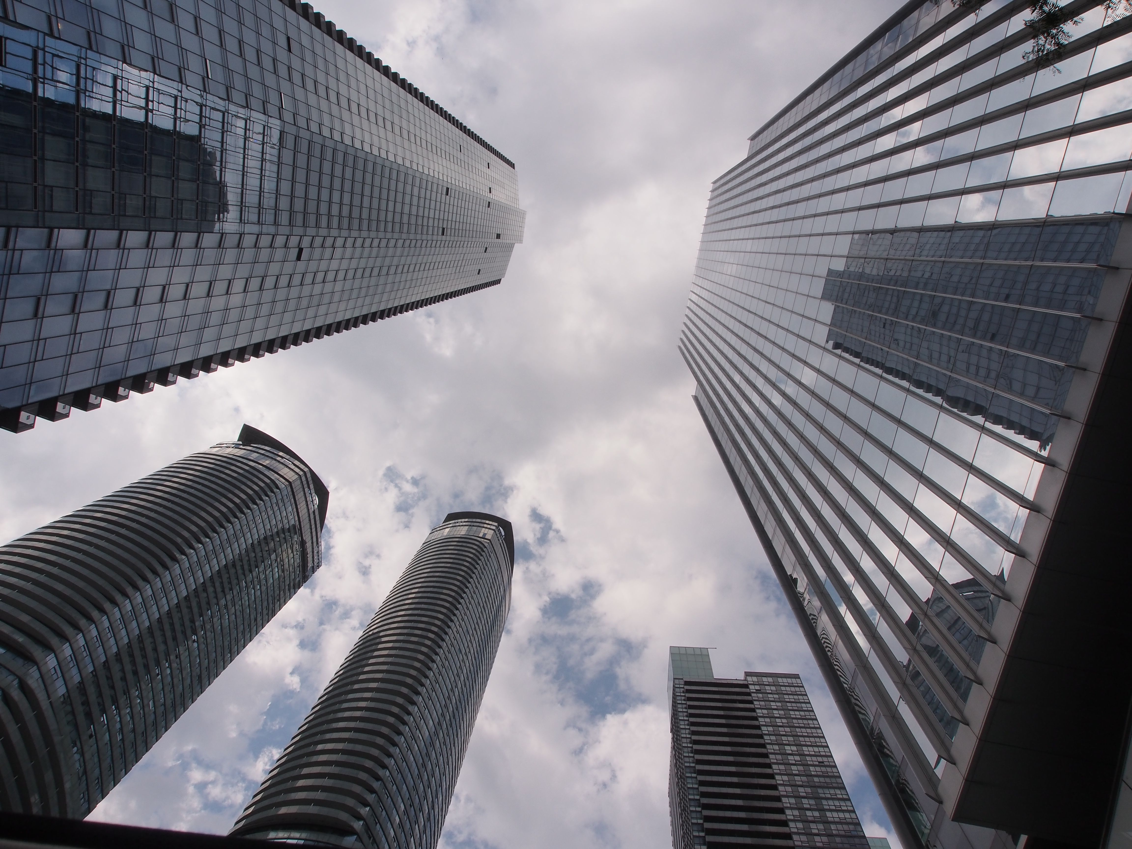 Modern skyscrapers reaching toward cloudy sky · Free Stock Photo