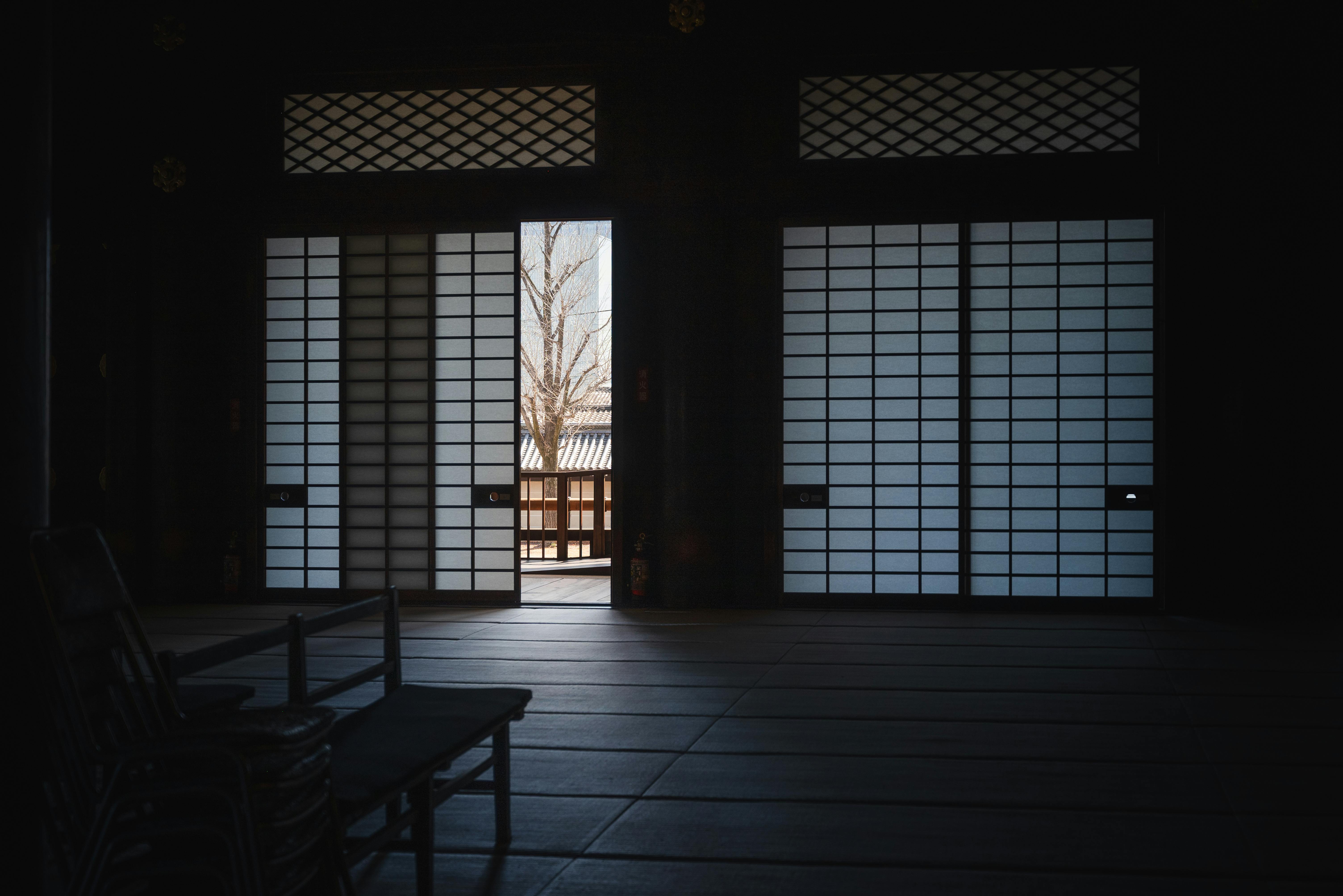 Vue sereine d'une chambre traditionnelle japonaise avec des portes shoji partiellement ouvertes à Kyoto.