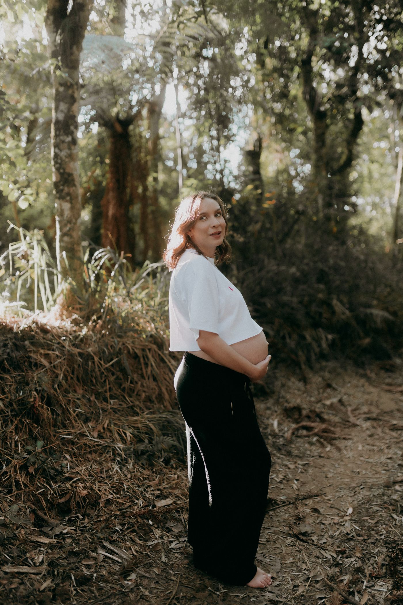 Femme enceinte marchant tranquillement sur un chemin ensoleillé