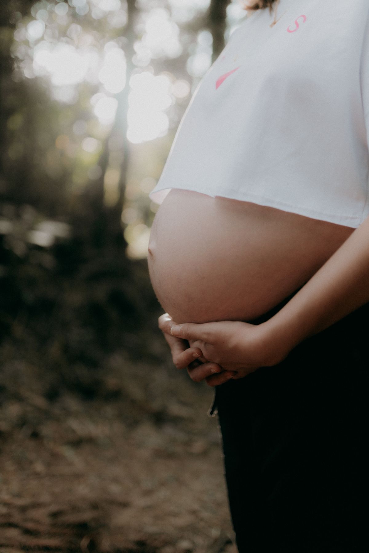 Pregnant woman embracing nature in a serene outdoor setting