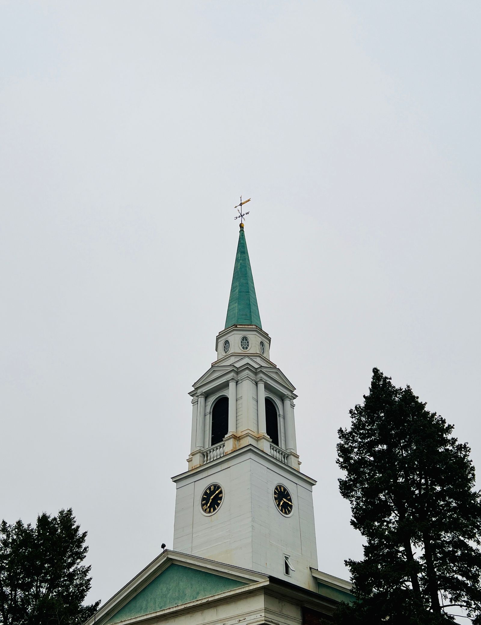 Traditional church tower with green steeple under overcast sky — Merrimack NH small-town character