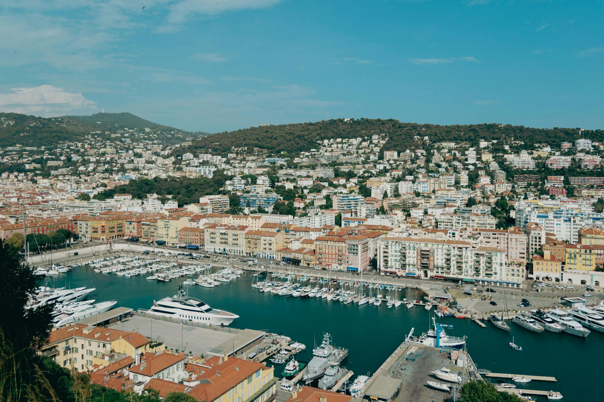 Aerial view of Nice harbor with yachts and hillside architecture in the French Riviera.