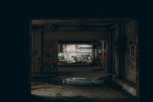 Free Explore the haunting beauty of an abandoned warehouse adorned with vibrant graffiti art. Stock Photo