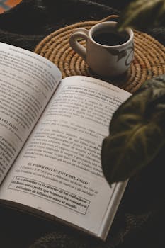 Warm indoor scene of an open book and coffee on a woven mat, perfect for relaxing.