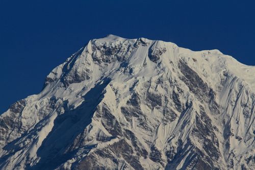 Free Snow-covered Annapurna peak in Nepal's Himalayas, captured in clear daylight. Stock Photo