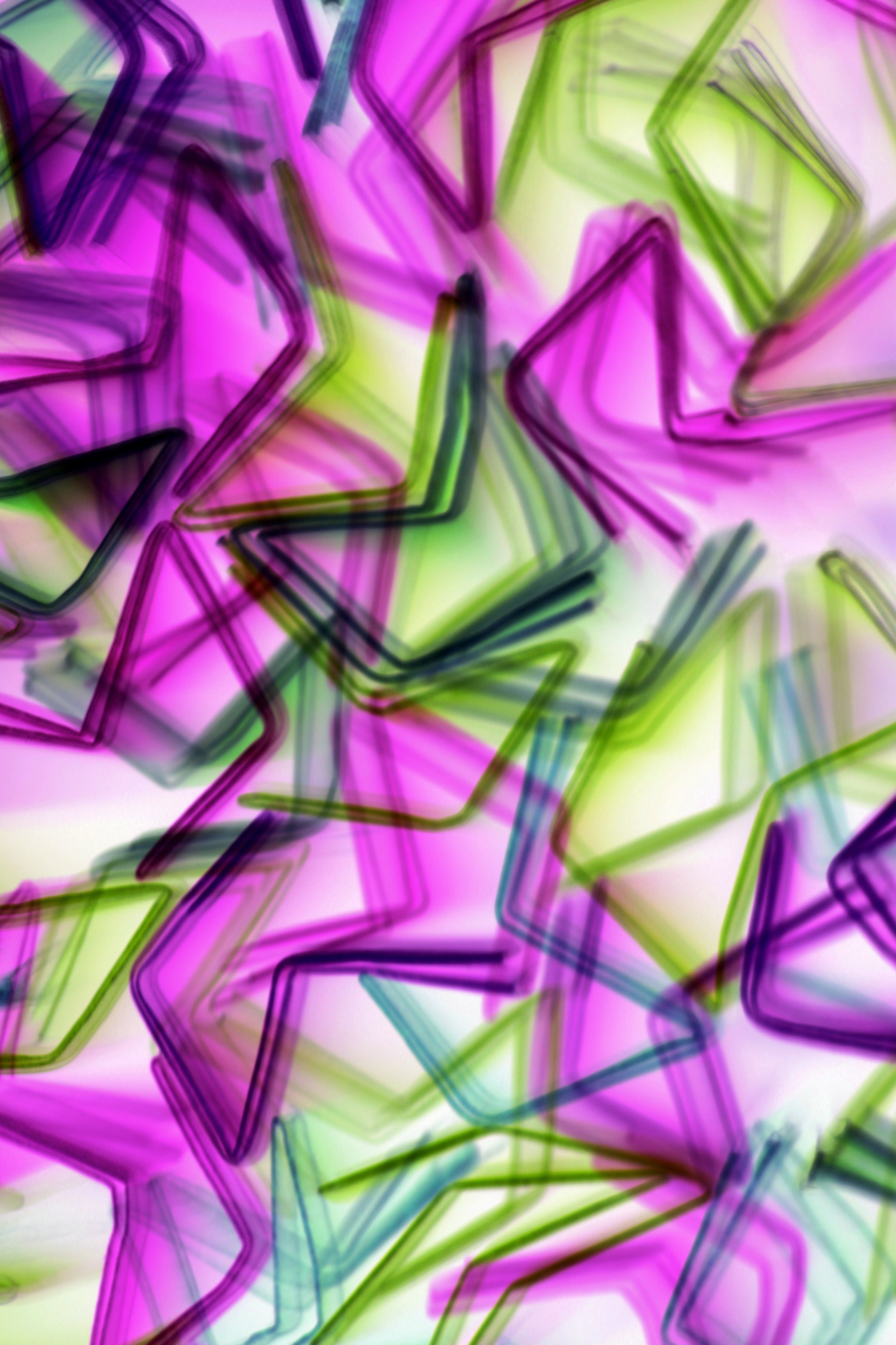 Colorful abstract artwork featuring overlapping star shapes in vibrant hues, creating a dynamic visual effect.