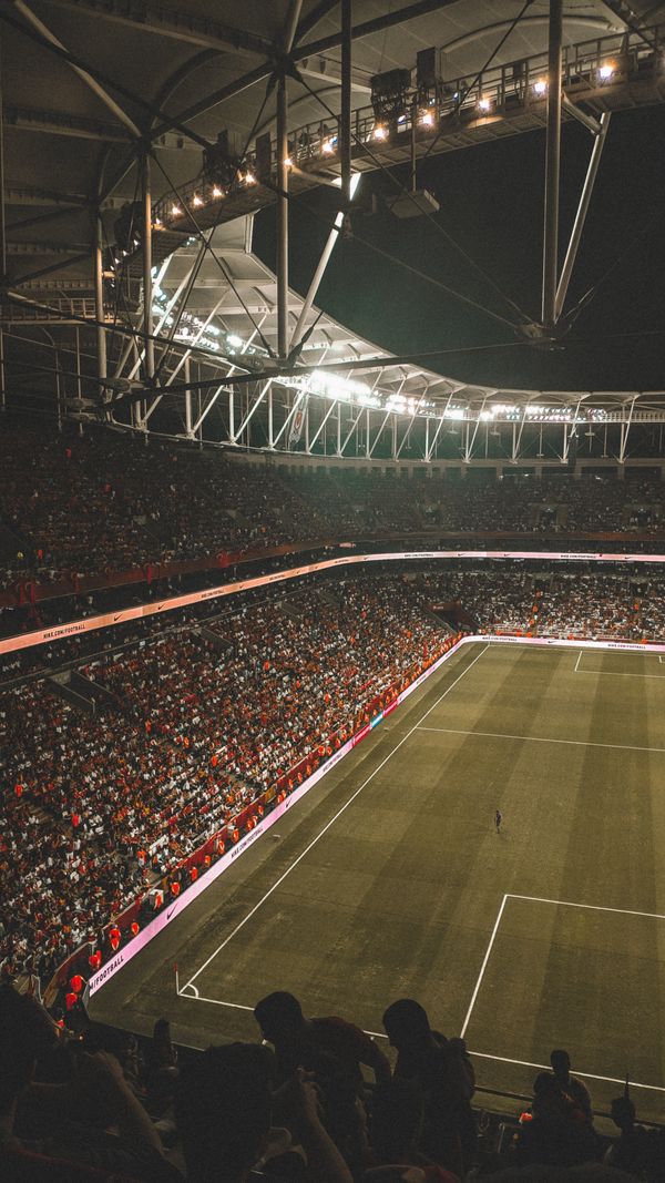 Packed arena under floodlights — photo by Furknsaglam on Pexels