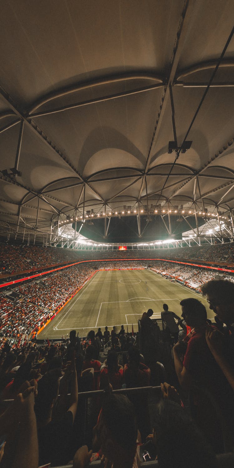 Fans Sitting On Tribunes In Football Stadium