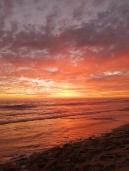 Captivating sunset view over Mazatlán beach with vibrant orange and pink hues reflecting on the ocean.