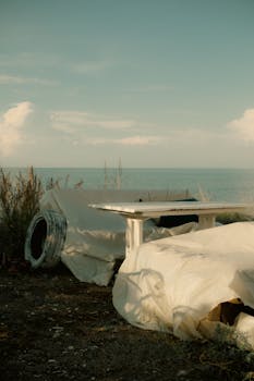 Abandoned furniture set near the sea, capturing a moody atmosphere during dusk.