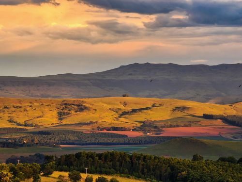 Free Captivating view of Drakensberg mountains with vibrant sunset skies and lush greenery. Stock Photo