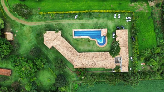 Scenic aerial view of a countryside estate featuring a swimming pool and lush greenery.