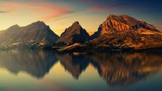 日落时分，宁静的湖面倒映着迷人的山景