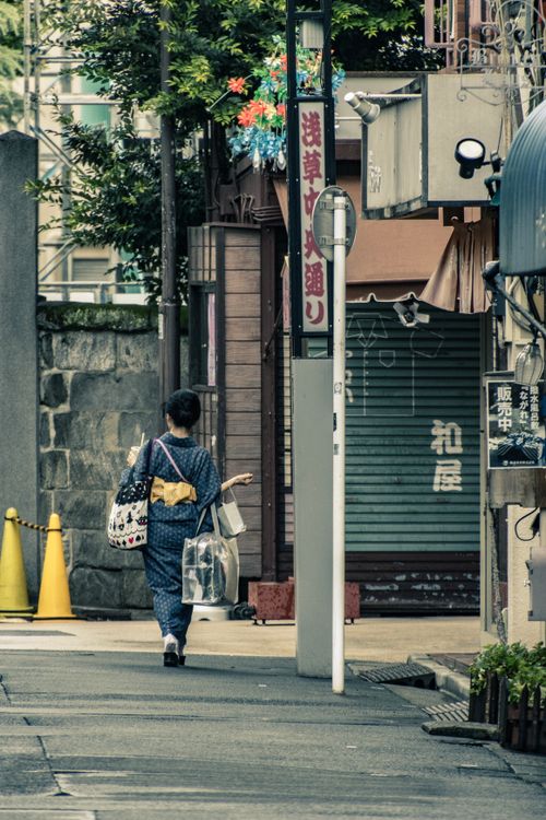 Free A pedestrian in traditional attire walks through a charming street in Tokyo, Japan. Stock Photo