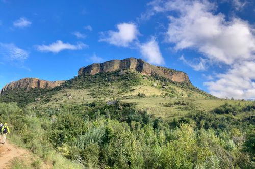 Free Beautiful mountain landscape under a blue sky with hikers exploring the greenery. Stock Photo