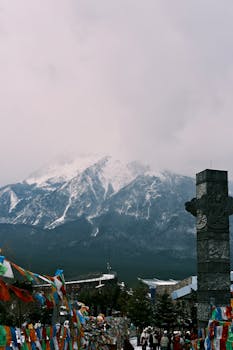 Stunning view of Jade Dragon Snow Mountain in Lijiang, China with vibrant prayer flags below.