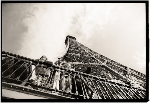 A view from below the Eiffel Tower capturing visitors in black and white.