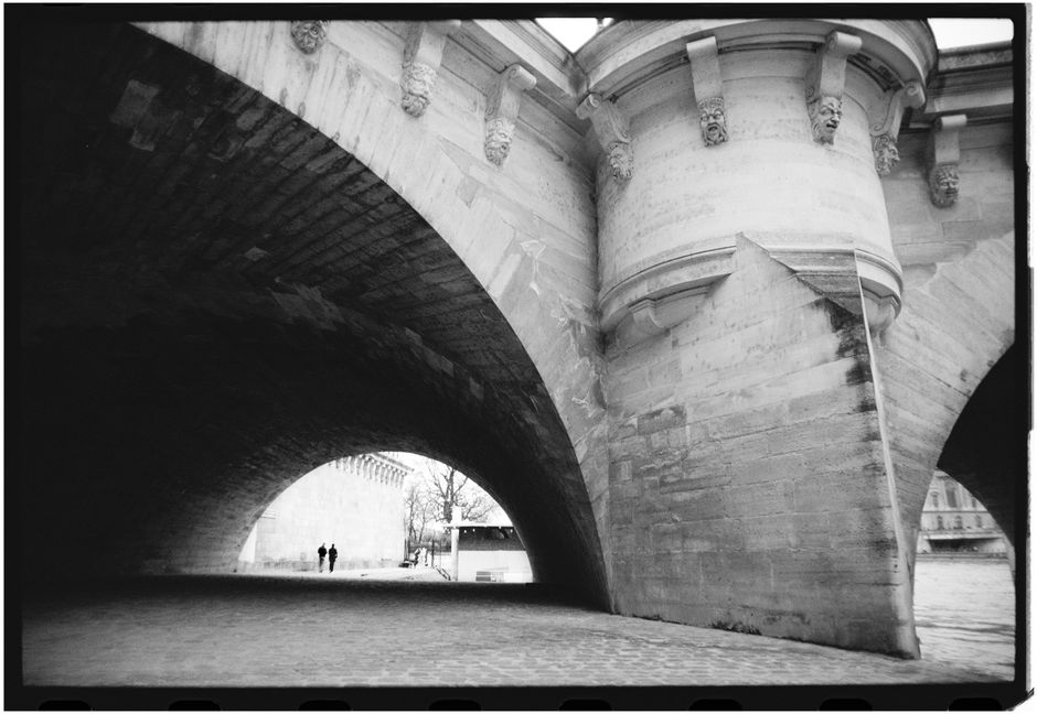 Atmospheric shot of a bridge arch in Paris, showcasing stunning architectural details.
