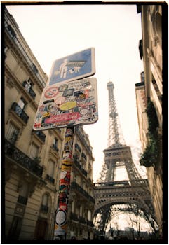 Street view of Eiffel Tower with unique urban signs and Paris architecture.