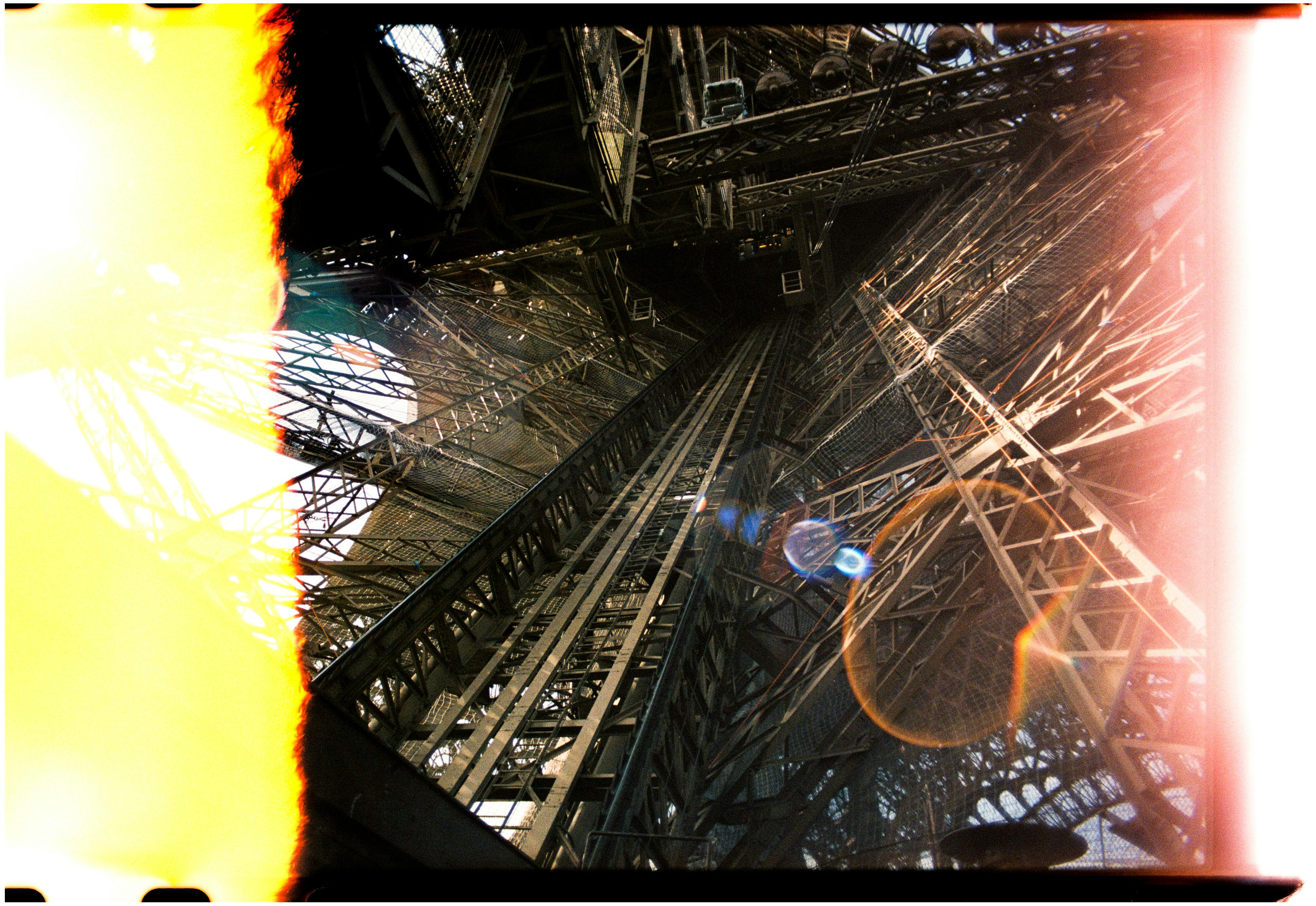 A captivating upward view of the Eiffel Tower's complex interior framework in Paris, France.