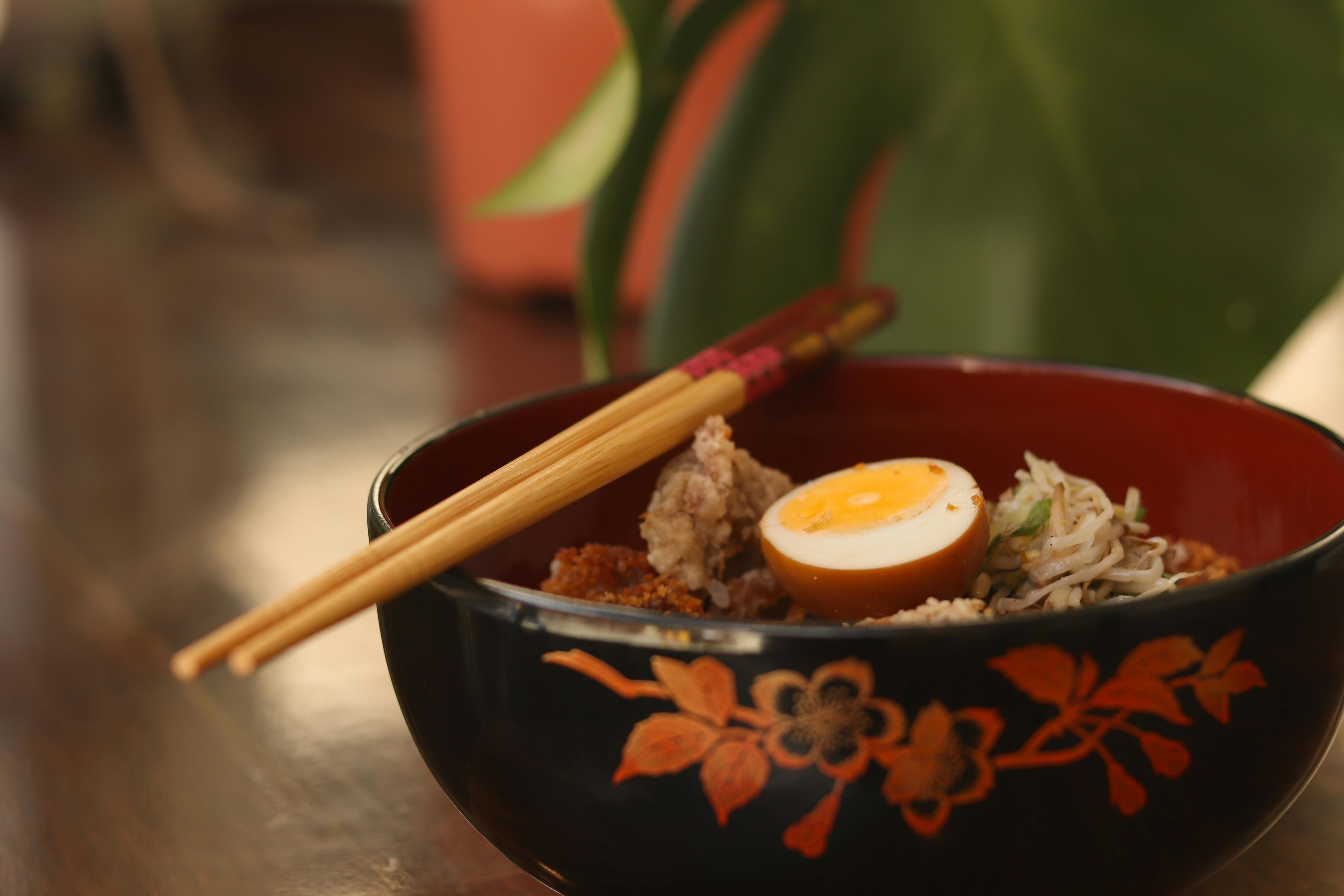 Elegant bowl of ramen with egg and chopsticks, perfect for food enthusiasts.