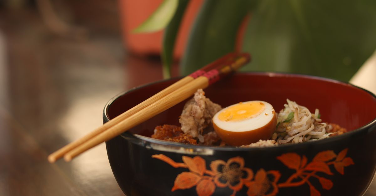 steaming bowl of birria ramen with tender shredded beef and soft boiled egg