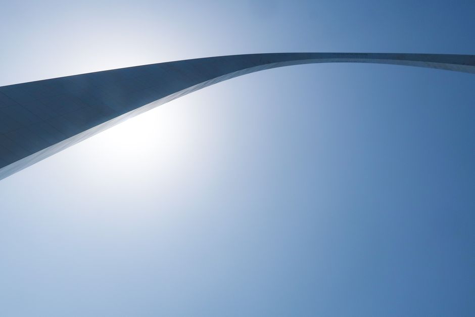A striking view of the Gateway Arch in St. Louis, Missouri, silhouetted against a clear blue sky.
