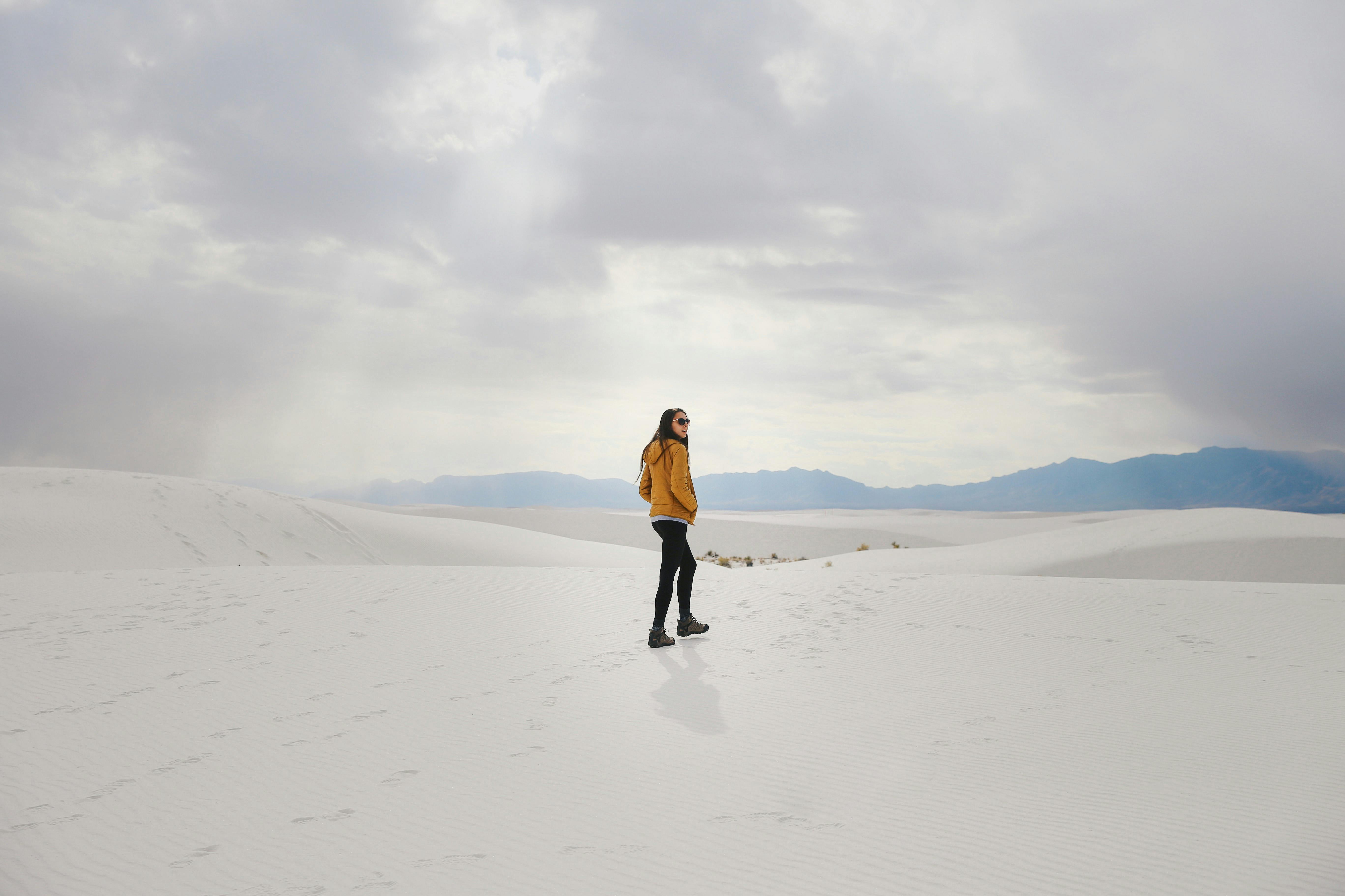 A solitary hiker explores the vast white dunes of White Sands National Park in New Mexico.