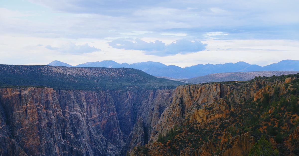 Explore the breathtaking cliffs of Black Canyon, Colorado under clear summer skies.