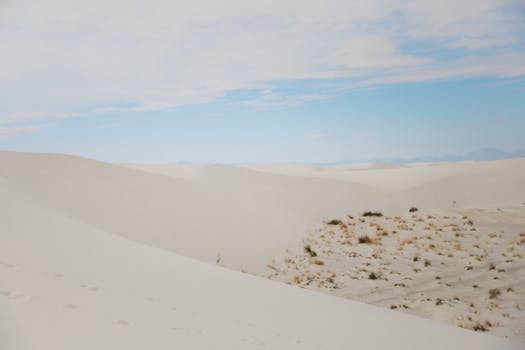 Explore the vast and serene white sand dunes of New Mexico under a clear blue sky.