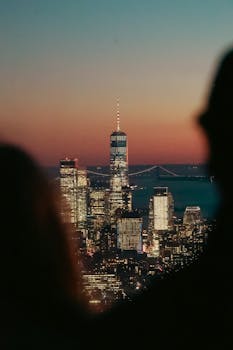 Breathtaking view of New York's skyline with the One World Trade Center during a colorful twilight.